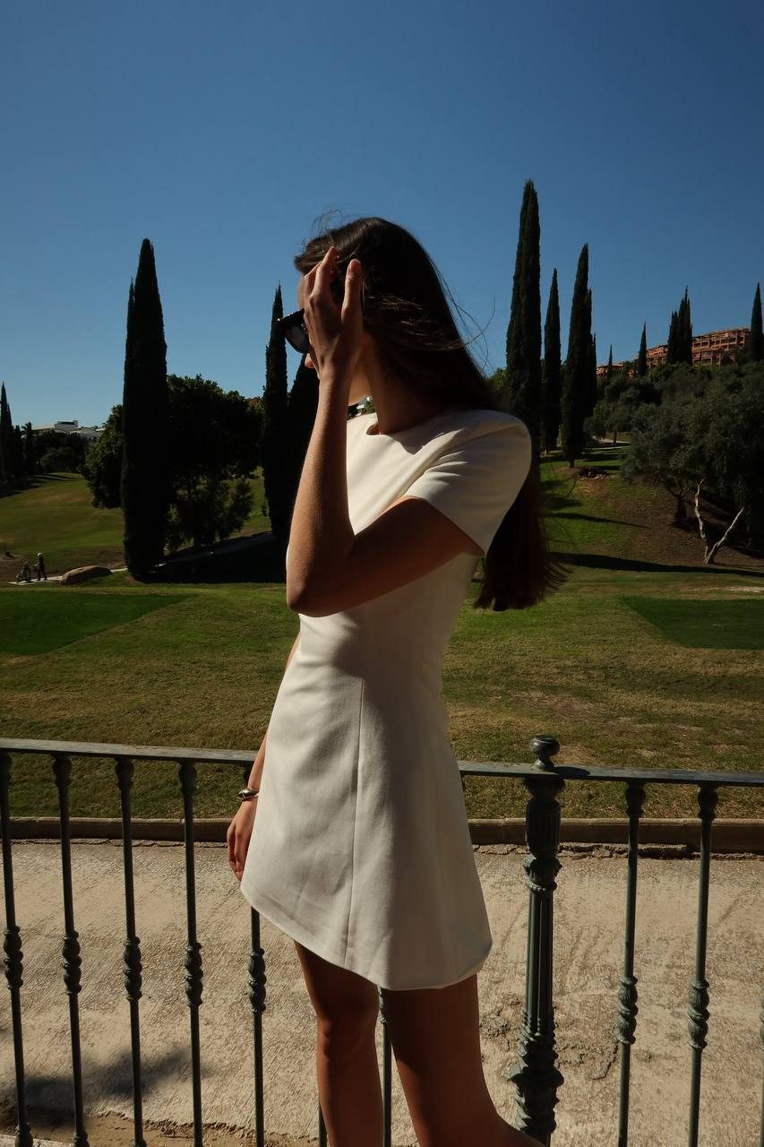 Anastasiia in a white dress on a terrace above the gardens